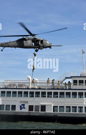 Coast Guard crewmembers from Maritime Safety and Security Team 91109, based in San Diego, fast-rope from a California Air National Guard 129th Rescue Wing HH-60G Pave Hawk helicopter during an interagency training exercise on the San Francisco Bay, April 25, 2017.  MSSTs train to detect and intercept potential threats before they reach our shoreline, disrupt our freedoms and our way of life. U.S. Coast Guard Stock Photo