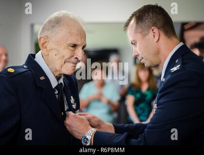 Retired Maj. Joe Campbell is awarded the Distinguished Flying Cross by Col. Ty Neuman, 2nd Bomb Wing commander, during an award ceremony at his residence in Shreveport, La., May 18, 2017. Campbell, a veteran of World War II, the Korean War, and Vietnam, received the award for heroism and extraordinary achievement during aerial operations in the Korean War. Stock Photo