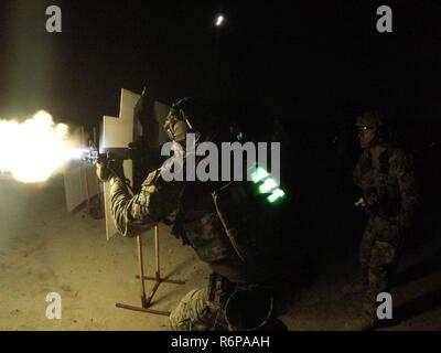 Chief Petty Officer Kelly, a Maritime Enforcement Specialist assigned to Tactical Law Enforcement Team South observes a shooter perform a low-light shooting drill during Advanced Marksmanship Instructor (AMI) course on Monday, May 29, 2017. AMI course teaches instructor candidates critical skills necessary to order to provide sustainment and proficiency training to members in the DSF.   U.S. Coast Guard Stock Photo
