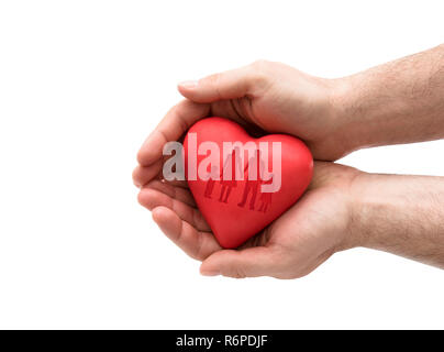 Red heart with imprinted family shape in man's hands. Stock Photo