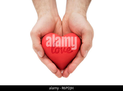 Red heart with imprinted love word in man's hands. Stock Photo