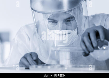 Life scientist researching in bio hazard laboratory. High degree of protection work. Stock Photo