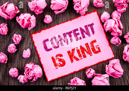 Handwriting text showing Content Is King. Business photo showcasing Online Marketing Information Management With cms Or Seo Data written on Pink Sticky Note Paper Folded Paper on wooden background Stock Photo