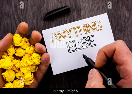 Conceptual text showing Anything Else. Business photo showcasing Ask Asking Question to Have Answer written on Notebook Book Man Writing Holding Pen wooden background Stock Photo