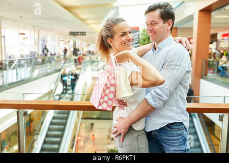 Happy young couple is having fun shopping together in shopping mall Stock Photo