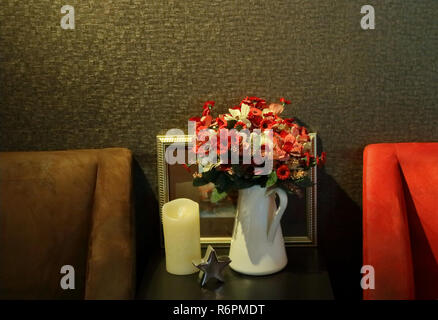 a bouquet of artificial flowers, white candle and star model on wooden table, celebration concept Stock Photo