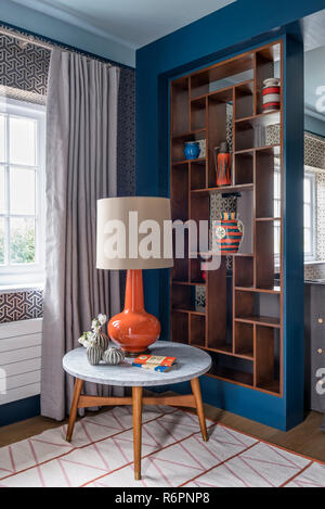 Retro lamp on marble side table with shelving partition in Hampshire Mill house redesigned by Emma Painter Stock Photo