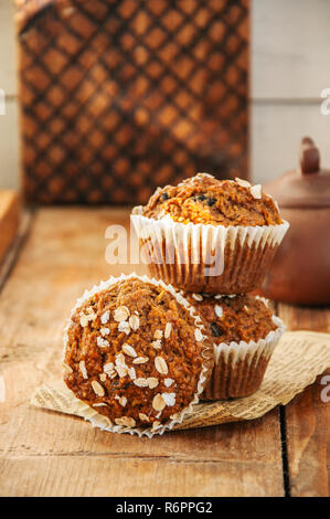 Carrot cake muffins with nuts, raisins and oats on a wooden background. Rustic style. Stock Photo