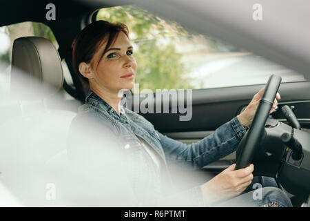 Middle age woman driving SUV car in traffic Stock Photo