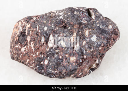 pebble of porous basalt stone on white marble Stock Photo