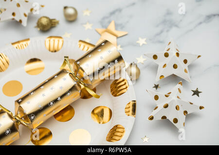 Festive Christmas party place setting with gold plate, cracker and decorations Stock Photo
