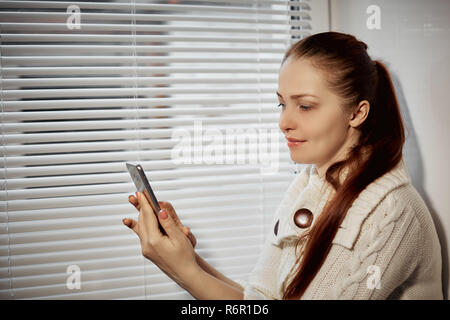 online shopping, a young woman browsing the goods in the online store on the smartphone screen Stock Photo