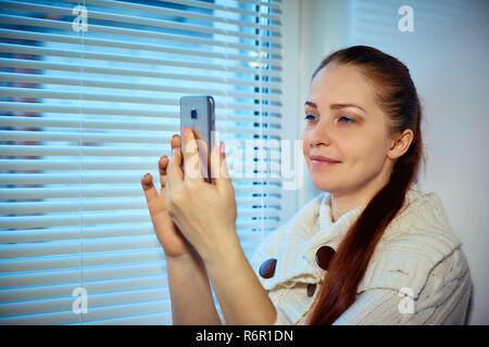 online shopping, a young woman browsing the goods in the online store on the smartphone screen Stock Photo