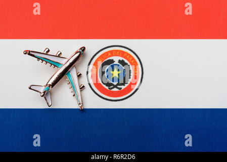 Airplane over the flag of Paraguay travel concept in the country. Toy plane, tourism and travel. Stock Photo