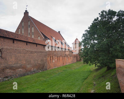 Malbork Castle, a UNESCO World Heritage Site in Malbork Poland built by the Teutonic Order, exterior view of moat between layers of red brick walls Stock Photo