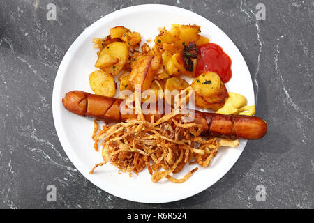 Close up portion of sausage with roasted potato Stock Photo