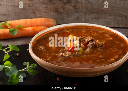 Easten Europ traditional soup or borsch made with beef meat and vegetables on a dark slate Stock Photo
