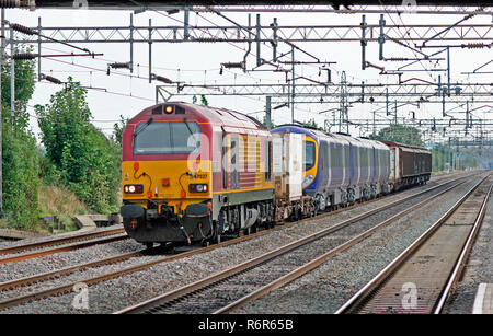 A class 67 diesel locomotive number 67027 'Rising Star' hauling barrier wagons and a class 185 diesel multiple unit number 185116 at Cheddington. Stock Photo