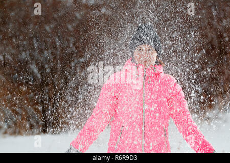Happy young woman playing with snow in the park. Winter concept. Stock Photo
