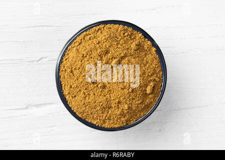 Caraway powder in round bowl on white wooden background, view directly from above. Stock Photo