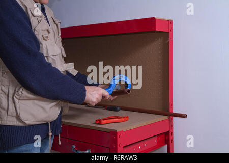 plumber at work on his workbench to fit pipes Stock Photo