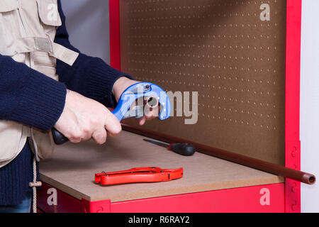 plumber at work on his workbench to fit pipes Stock Photo