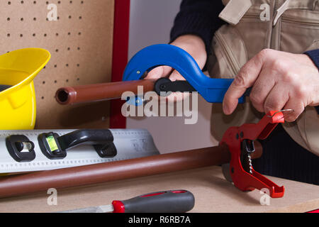plumber at work on his workbench to fit pipes Stock Photo