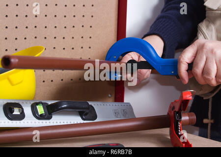 plumber at work on his workbench to fit pipes Stock Photo