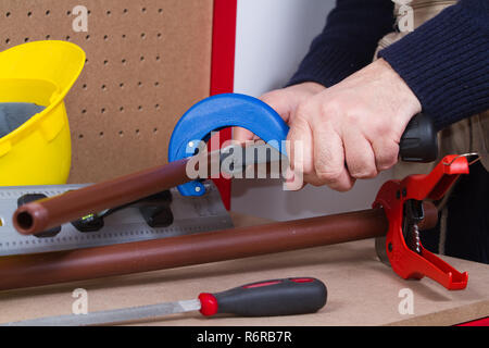 plumber at work on his workbench to fit pipes Stock Photo