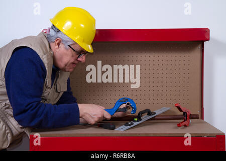 plumber at work on his workbench to fit pipes Stock Photo