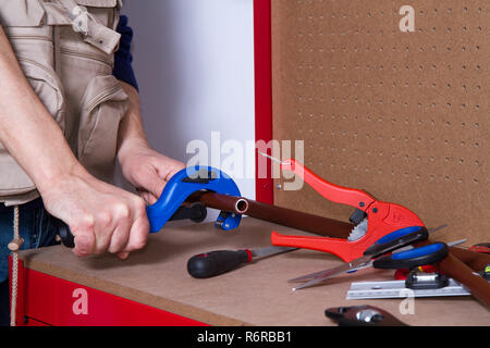 plumber at work on his workbench to fit pipes Stock Photo