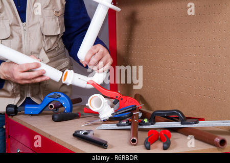 plumber at work on his workbench to fit pipes Stock Photo
