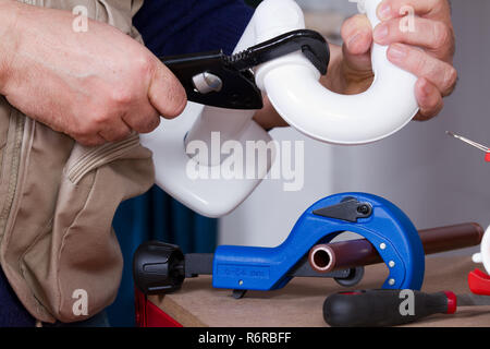 plumber at work on his workbench to fit pipes Stock Photo