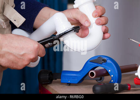 plumber at work on his workbench to fit pipes Stock Photo