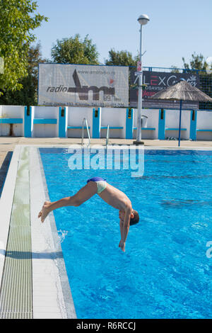 Seven year old boy doing swimming pool  dive stop action shot