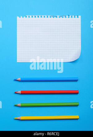 white blank sheet in a box from a notebook with holes and multi-colored wooden pencils Stock Photo