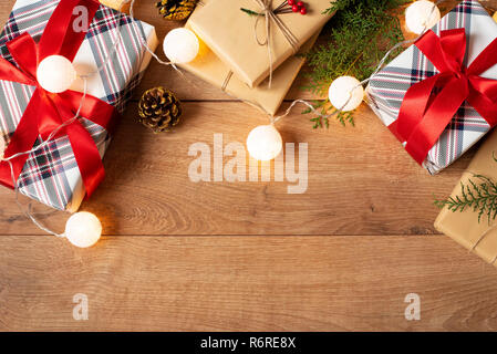 Christmas background with decorations, lights and gift boxes on wooden board. Festive backdrop for winter holidays: Birthday, Valentines day, Christma Stock Photo