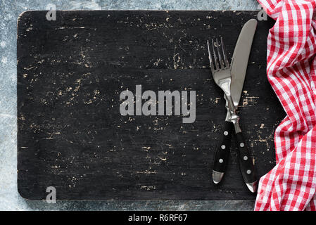 Blackboard or black cutting board and cutlery, food background with copy space for text. Web banner, design, menu concept Stock Photo