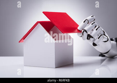 Robot Building House With Red Roof Stock Photo