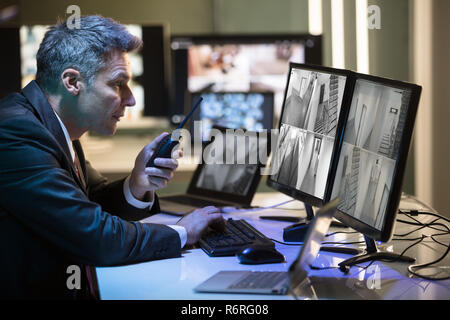 Side View Of A Businessman Talking On Walkie Talkie Stock Photo