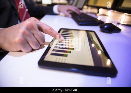 Businessperson Looking At Financial Graph On Digital Tablet Stock Photo