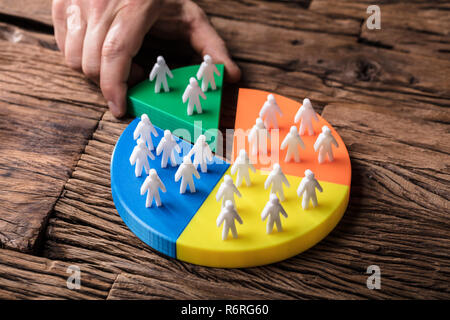 Placing A Last Piece With Human Figures Into Pie Chart Stock Photo