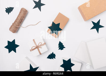 Flat lay arrangement of Christmas gifts and decorations of black paper in shape of stars and fir trees, top view. Stock Photo