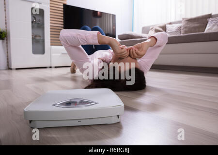 Close-up Of A Weighing Scale On Hardwood Floor Stock Photo