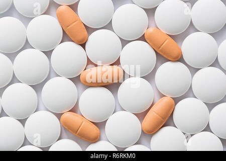 White and orange pills closeup. View from above Stock Photo