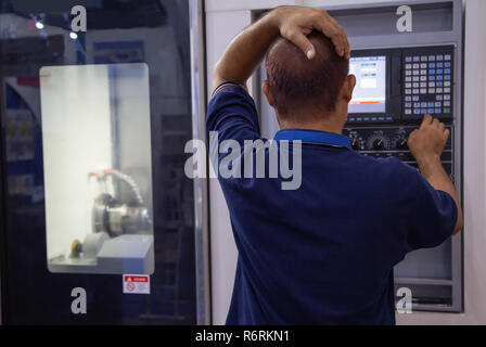 Industrial worker input data programing for CNC lathing machine Stock Photo