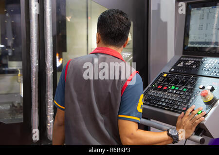 Industrial worker input data programing for CNC milling machine Stock Photo