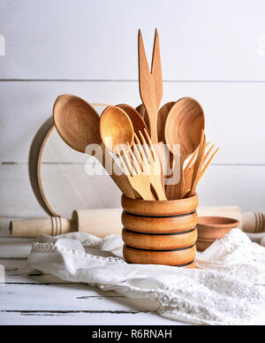 Wooden kitchen utensils on white background. Cutting board, fork