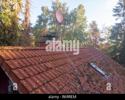 Inspection of the red tiled roof of a single-family house, inspection of the condition of the tiles on one roof side Stock Photo