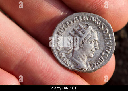 Hand holding Roman denarius (Roman silver coin) Stock Photo